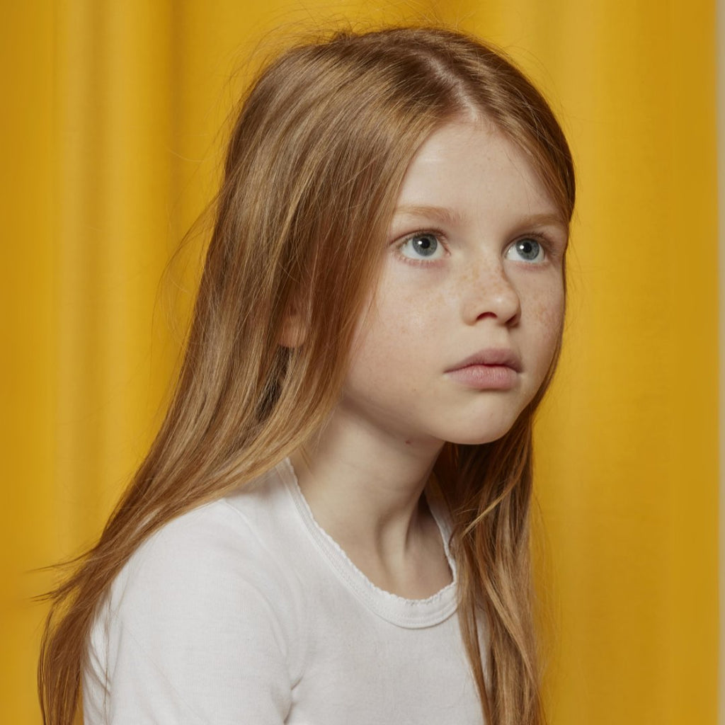 images of baby, girl, boy, and woman on a yellow curtain background