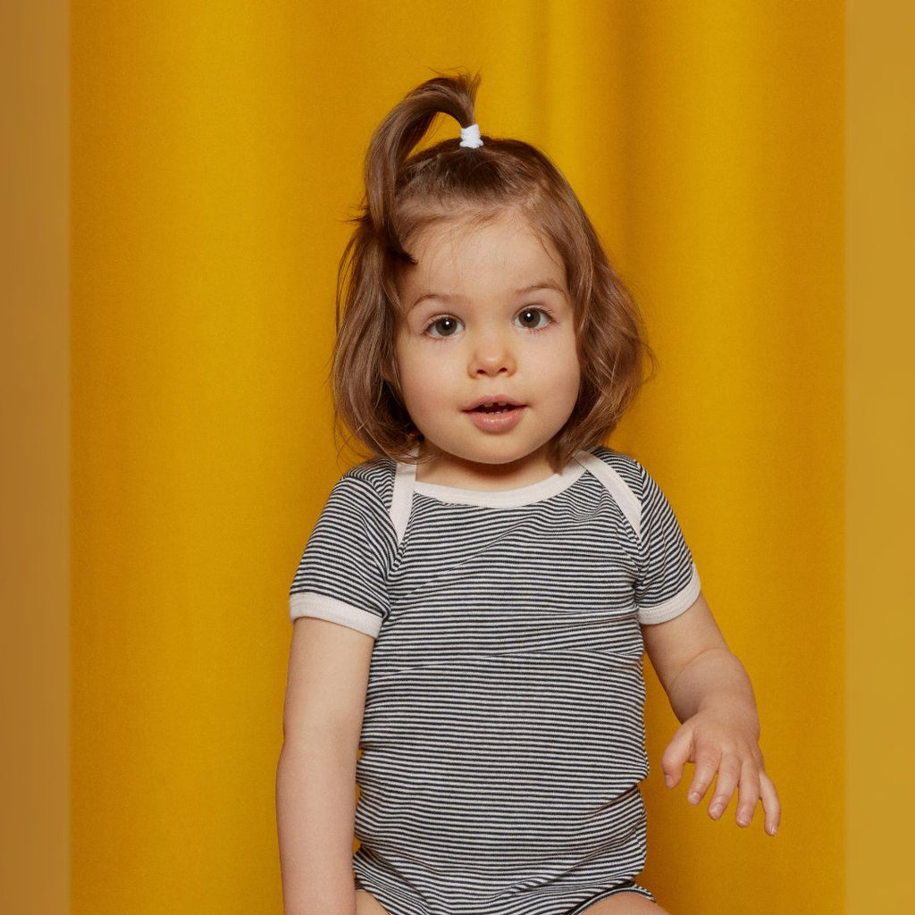 images of baby, girl, boy, and woman on a yellow curtain background