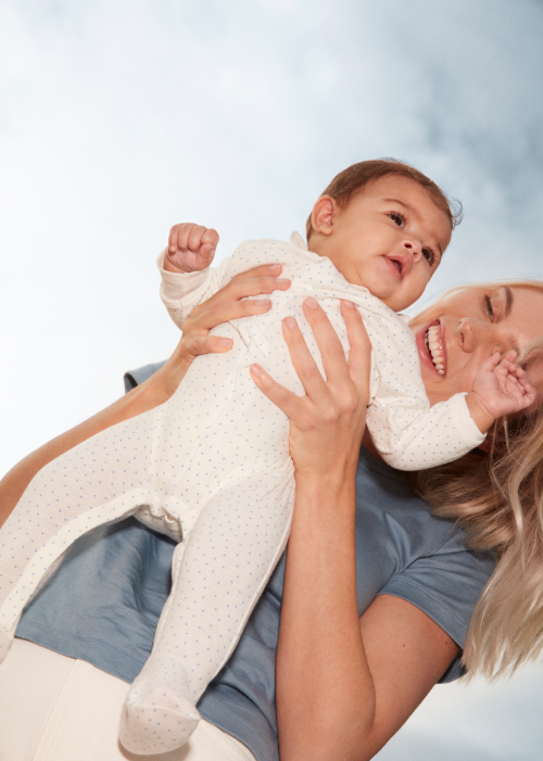 A smiling woman holding a baby